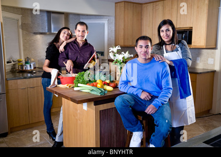 Famille avec adolescents hispaniques cooking together in kitchen Banque D'Images