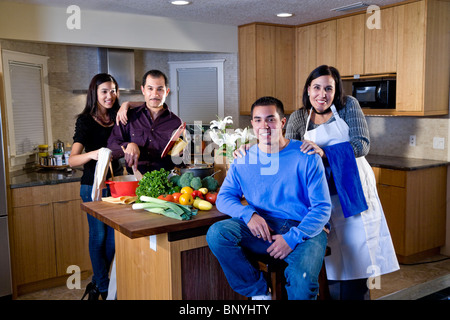 Famille avec adolescents hispaniques cooking together in kitchen Banque D'Images