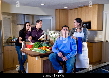 Famille avec adolescents hispaniques cooking together in kitchen Banque D'Images