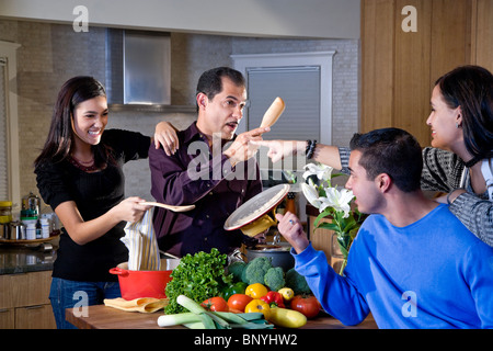 Famille avec adolescents hispaniques cooking together in kitchen Banque D'Images