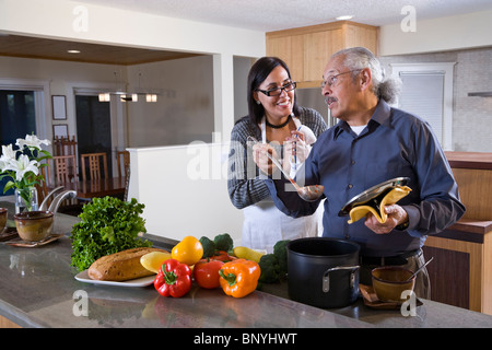 Senior Hispanic couple la cuisson des aliments dans la cuisine à la maison Banque D'Images