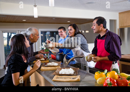 Mère hispanique servant des repas maison dans la cuisine de la famille Banque D'Images