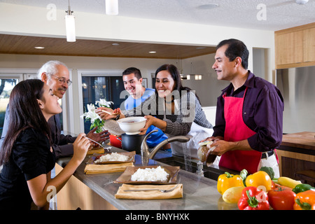 Mère hispanique servant des repas maison dans la cuisine de la famille Banque D'Images