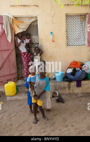Afrique, Sénégal, Dakar. Village Wolof, le plus grand groupe ethnique du Sénégal. Grande famille typique en face de la maison. Banque D'Images
