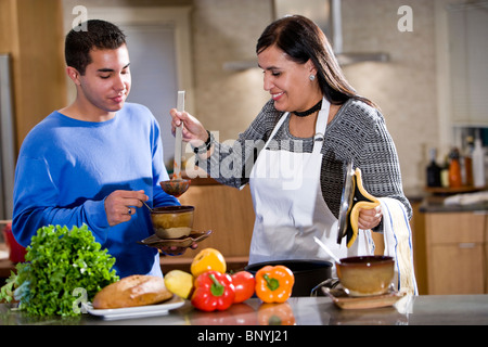 Mère et fils adolescent hispanique cuisiner à la maison dans la cuisine Banque D'Images