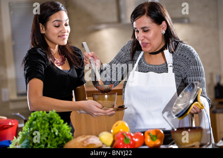 Mère et fille adolescente hispanique cuisiner à la maison dans la cuisine Banque D'Images