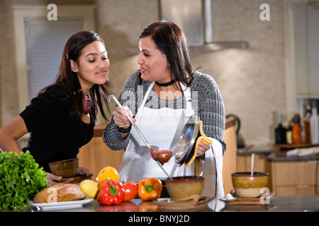 Mère et fille adolescente hispanique cuisiner à la maison dans la cuisine Banque D'Images