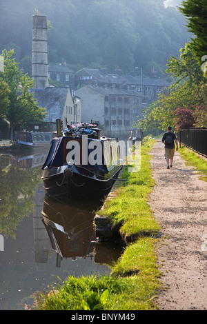 Walker sur chemin de halage de Rochdale Canal et amarré narrowboats à Hebden Bridge Calderdale West Yorkshire UK Banque D'Images