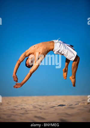 Jeune homme sautant sur plage. Banque D'Images Jeune homme sautant sur plage. Banque D'Images