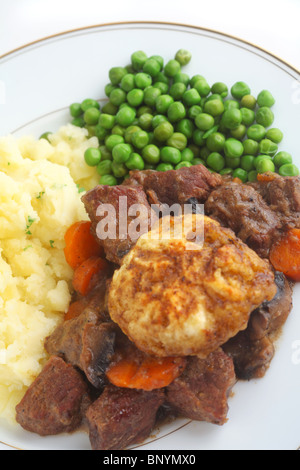 Ragoût de boeuf britannique traditionnel et dumpling avec de la purée de pommes de terre et persil pois bouillis. Banque D'Images