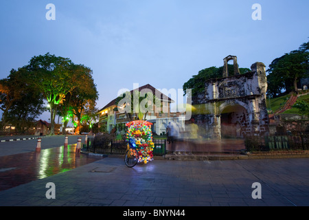 Le Trishaw flashy location en face de Porta da Santiago, porte principale de la forteresse A'Famosa, Melaka en Malaisie. Banque D'Images