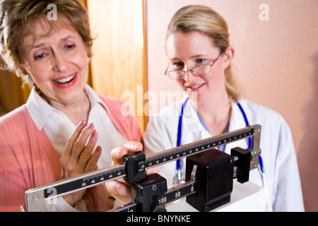 Senior woman standing sur échelle dans le cabinet du médecin Banque D'Images