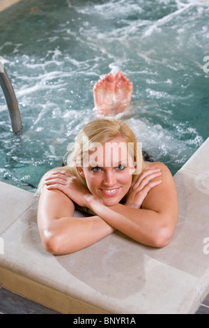 Belle jeune femme de vous détendre dans le bain à remous du spa Banque D'Images