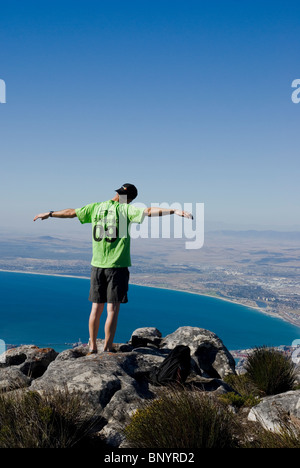 Un homme intensément bénéficie de l 'au sommet du monde" au sommet de Table Mountain, Cape Town, Afrique du Sud. Banque D'Images
