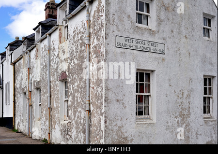 Vieilles maisons blanches et plaque de rue en gaélique à Ullapool, Highlands, Scotland, UK Banque D'Images
