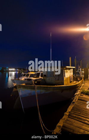 Bateau de pêche anciens accoste au quai le long du boulevard du Dodécanèse dans la nuit à Tarpon Springs, Floride Banque D'Images