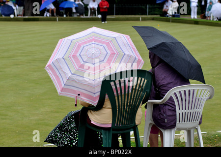 Les gens avec des parasols en regardant mes chers bols correspond à Banque D'Images