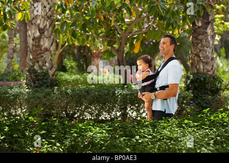 Père marchant avec bébé dans park Banque D'Images