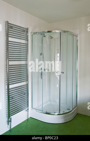 Un porte-serviettes chauffant et une douche d'angle dans une salle de bains moderne, Royaume-Uni Banque D'Images