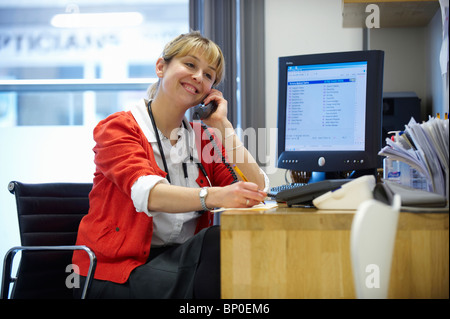 Femme médecin sur téléphone in office Banque D'Images