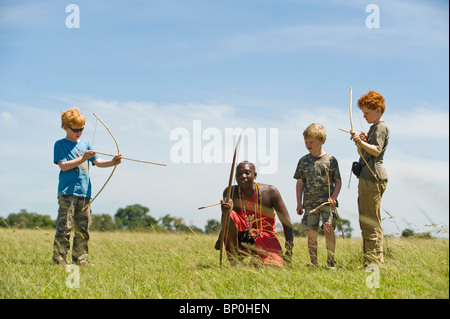 Au Kenya, le Masai Mara. Guide de Safari, Salaash Morompi Ole, enseigne aux enfants massaïs de tir à l'élégance. (MR) Banque D'Images