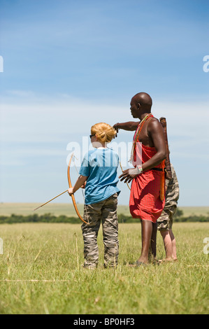 Au Kenya, le Masai Mara. Guide de Safari, Salaash Morompi Ole, enseigne aux enfants massaïs de tir à l'élégance. (MR) Banque D'Images
