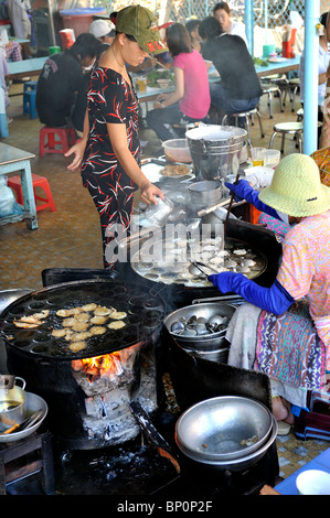 Les poêles à bois mis en place dans un restaurant en plein air, de faire le toujours populaire 'banh khot' (petites crêpes). Vung Tau, Vietnam Banque D'Images