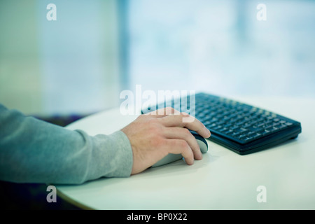 Businessman's main sur la souris de l'ordinateur Banque D'Images