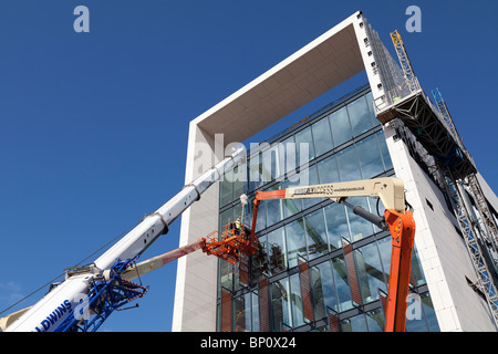 Les travailleurs de la construction travaillent en hauteur pour installer bardage sur le Sud de l'unité de commandement opérationnel Southampton Banque D'Images