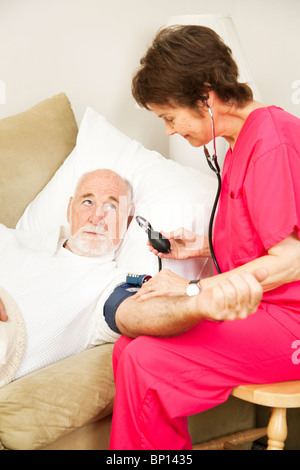 Accueil santé infirmières âgées prenant une pression artérielle du patient. Vue verticale. Banque D'Images