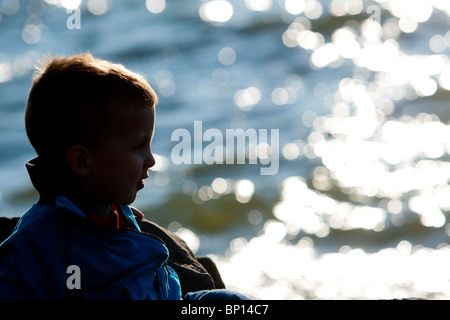 Un enfant de deux ans porte sur le coucher de soleil sur le fleuve Saint-Laurent à St-Michel-De-Bellechasse, Québec Banque D'Images