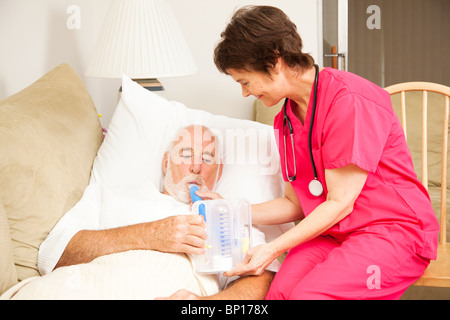 Accueil santé infirmières aide a senior patient avec sa thérapie respiratoire. Banque D'Images