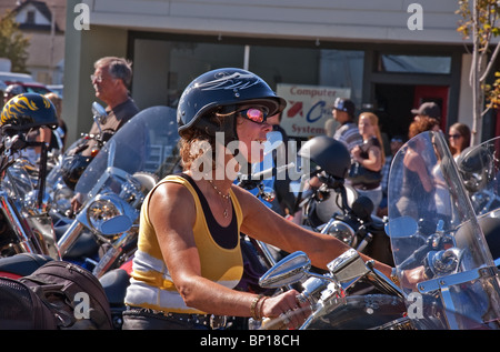 Cette femme de race blanche non identifiés est souriante et confiante comme elle chevauche sa motocyclette à l'Huître annuel rallye moto Run Banque D'Images