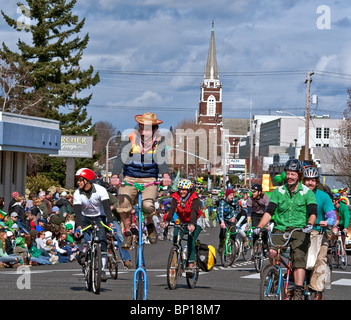 Cet éditorial image sont des cyclistes, la personne centrale sur un très grand vélo, équitation dans la Saint Patrick's Day Parade. Banque D'Images