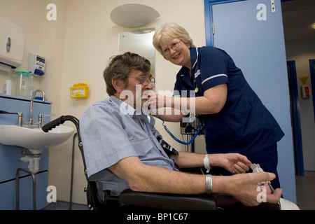 Infirmière Linda Knowles prend la pression artérielle d'un patient à l'Hôpital St Mary à Newport. Banque D'Images
