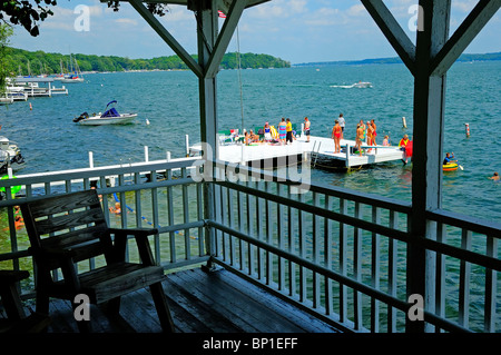 L'activité d'été sur le lac avec chaise vide sur porche surplombant l'amusement. Banque D'Images