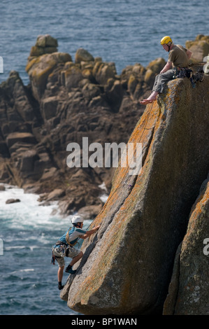 Les grimpeurs sur des rochers sur la côte de Gwennap Head à Cornwall. Banque D'Images