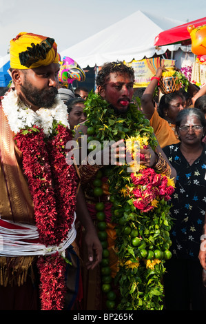 Les dévots hindous portant portant des guirlandes de fruits et fleurs pendant Thaipusam Festival à Batu Caves à Kuala Lumpur Banque D'Images