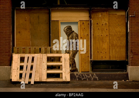 L'art du graffiti montrant un homme dans un hoody peints dans une porte en bois, dans le quartier Soho de New York City, USA. Banque D'Images