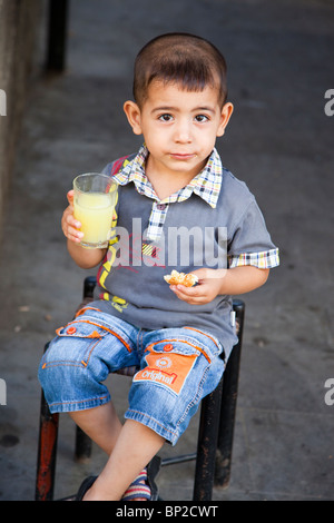 Jeune garçon manger dans la vieille ville de Diyarbakir, est de la Turquie Banque D'Images