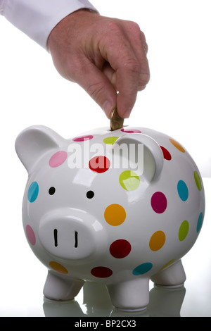 À pois blanc tirelire avec homme part déposer de l'argent Banque D'Images