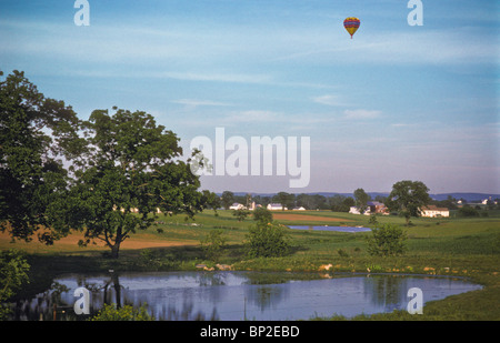 Hot Air Balloon riders soar , flotter au-dessus des champs de ferme, Lancaster. Banque D'Images