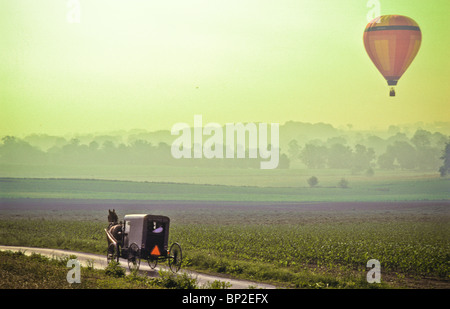 Hot Air Balloon riders soar , flotter au-dessus des champs de ferme de Lancaster, tôt le matin. Banque D'Images