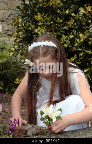 Portrait d'une jeune fille à sa première communion en Irlande la cueillette des fleurs Banque D'Images