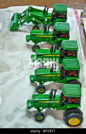 Rangée de 5 John Deere vert tracteurs jouets anciens de préparation pour une antique show, fraîchement lavés et sécher sur une serviette. Banque D'Images