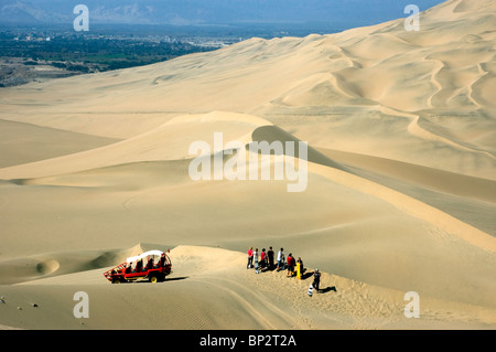 Les voiturettes de dunes avec les touristes des sables sur le vaste désert de dunes de sable près de l'Oasis de Huacachina, Ica, Pérou. Banque D'Images
