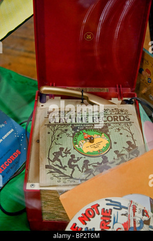Ancien joueur d'enregistrement rouge avec quelques albums de différents dossiers (vinyls) y compris quelques vieux 45 tours. Les souvenirs de retour fait revivre le passé. Banque D'Images