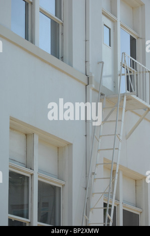 L'échelle de sortie de secours et l'escalier peint en blanc pour correspondre au côté d'un bâtiment blanc propre. Banque D'Images