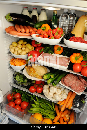 Vue à l'intérieur de réfrigérateur avec des étagères remplies de produits frais Banque D'Images