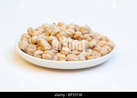 Close-up de pois chiches dans un bol blanc sur fond blanc Banque D'Images